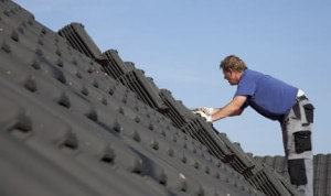 Vakman voert reparatie aan dak uit